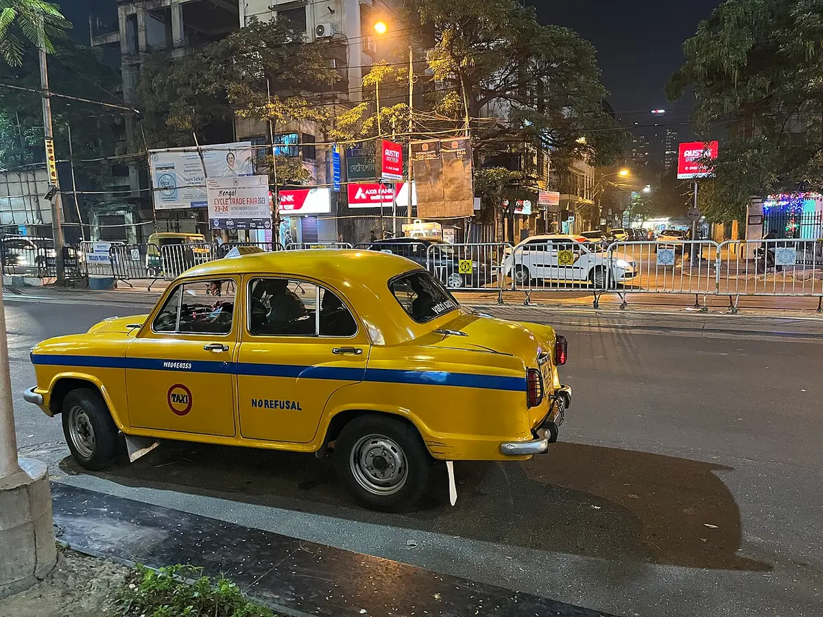 A yellow taxi on a Kolkata street at night